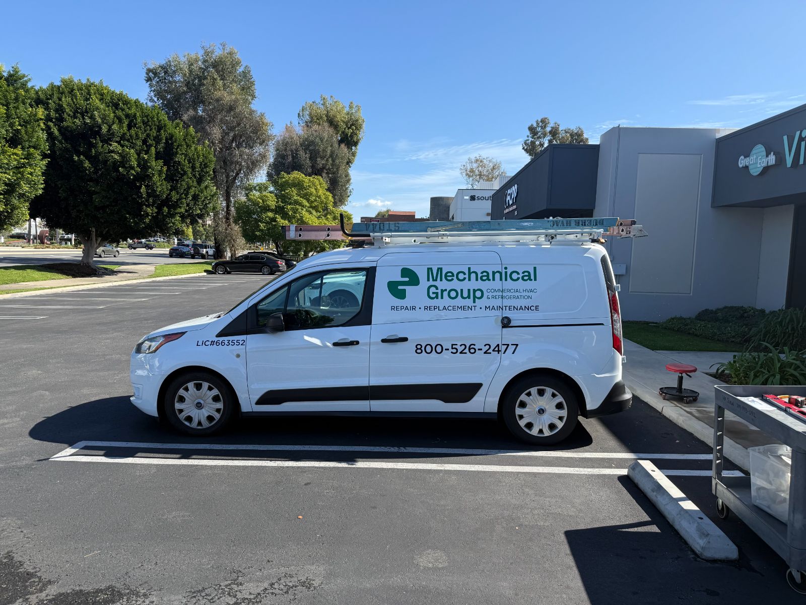 Driver side of a white Ford Transit Connect van with Mechanical Group graphics: green-and-black cut vinyl logo, 'Commercial HVAC & Refrigeration' tagline, license number and phone number