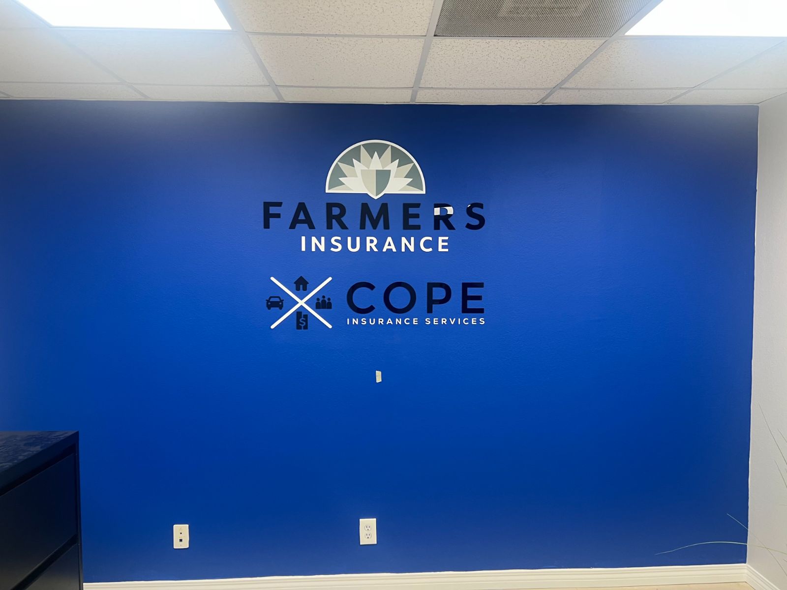 Royal-blue office wall with a Farmers Insurance logo and dimensional letters