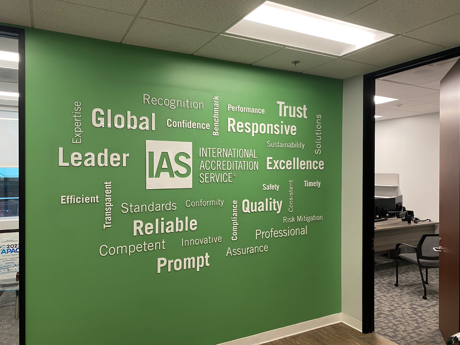 The full green word-cloud wall photographed straight on, the complete cut-vinyl layout visible corner to corner