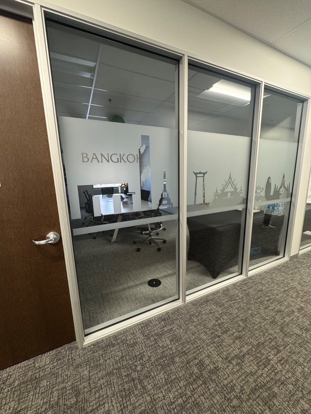 Bangkok room front from the opposite approach, frosted privacy film aligned across each glass panel