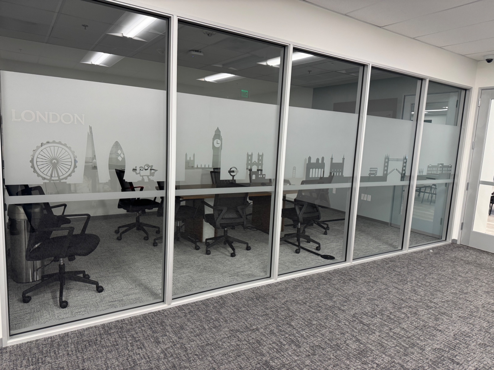 London room glass photographed straight on, frosted band carrying a Ferris wheel, Big Ben and Parliament silhouettes