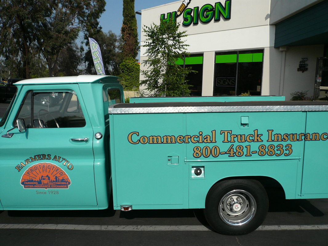 Restored turquoise service truck parked outside the Hi Sign shop with gold cut-vinyl lettering reading 'Commercial Truck Insurance' and a phone number on the utility bed, and a Farmers Auto seal on the door